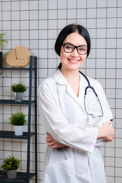 아름다운 웃는 의사 옷을 입고 현대식 사무실에 서 있는 모습 — 스톡 사진