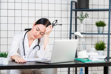 Portre portre mutsuz mutsuz sağlık profesyonel baş ağrısı ile uykulu holding fincan kahve vurguladı. Hemşire Doktor migren ile overstressed overworked.