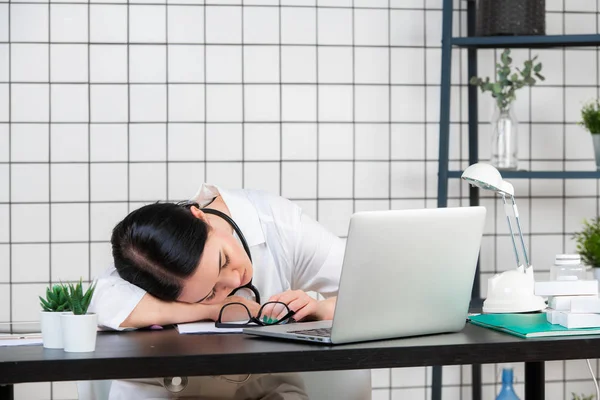 Kvinde læge sover på skrivebordet i medicinsk kontor, Træt arbejdstager, Asiatisk model, Medicinsk og sundhedspleje koncept . - Stock-foto