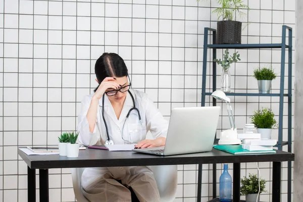Disperato medico femminile seduto nel suo ufficio — Foto Stock