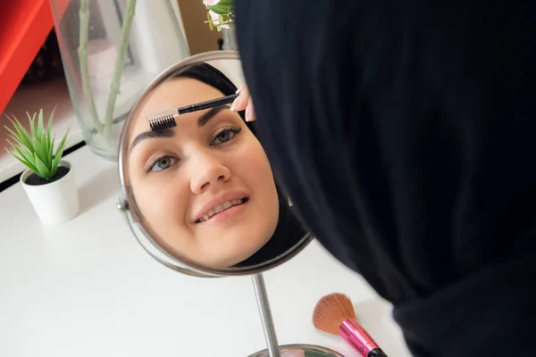 Arabská žena použití make-up na tváři, nosí tradiční arabský oděv — Stock fotografie