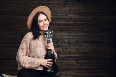 Genç ve güzel kadın ülke tarzda giyinmiş onun gitar sarılma