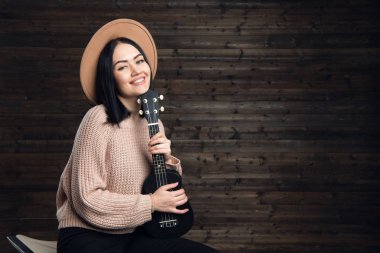 Gitar çalmak bir ahşap duvara genç kız