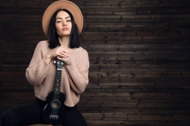 Genç ve güzel kadın ülke tarzda giyinmiş onun gitar sarılma