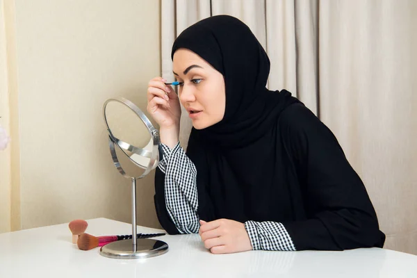 Hermosa mujer musulmana aplicando rímel. Mujer árabe joven usando cepillo de pestañas — Foto de Stock