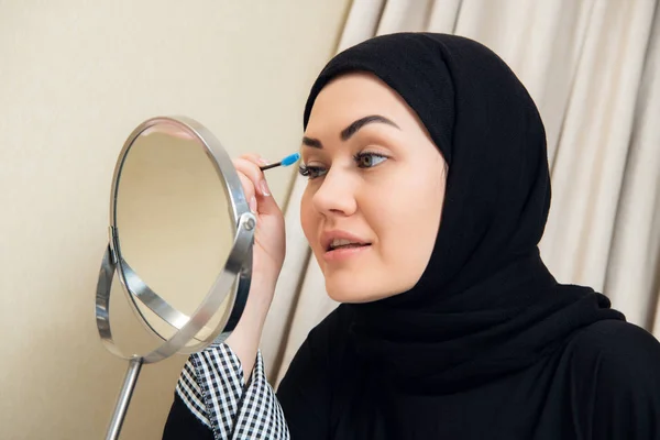 Hymyilevä nuori nainen yllään meikki ja hijab — kuvapankkivalokuva