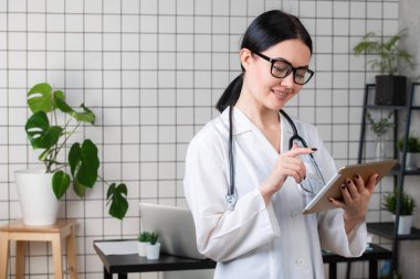 Ofiste dijital tabletini kullanan kadın doktorun portresi..