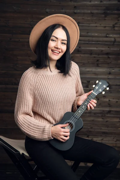 Unga vackra kaukasiska kvinna i casual spela liten gitarr — Stockfoto