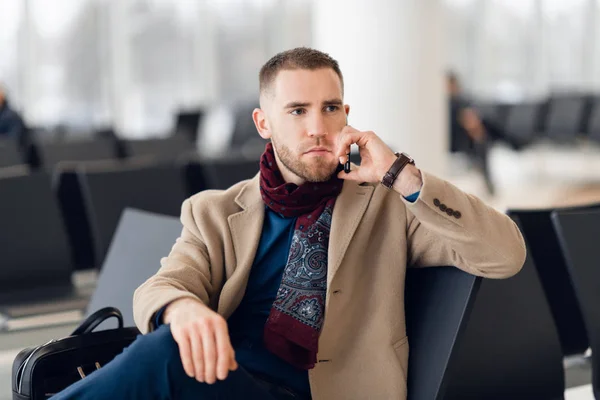 Handsome hipster modern businessman with beard calling on mobile phone at airport or office building — Stock Photo, Image