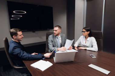 Başlangıç iş, farklı yaş ve ırklar yaratıcı iş adamları karanlık modern ofis iç toplantı odasında toplamak, canlı tartışıyor