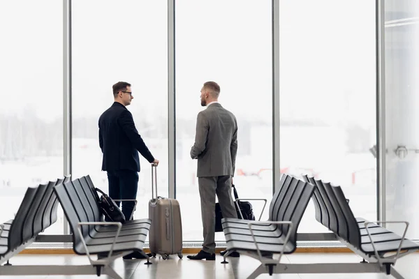 출발 게이트 근처 의 wating 지역에서 공항에서 큰 창 앞에 서 두 사업가의 실루엣 — 스톡 사진