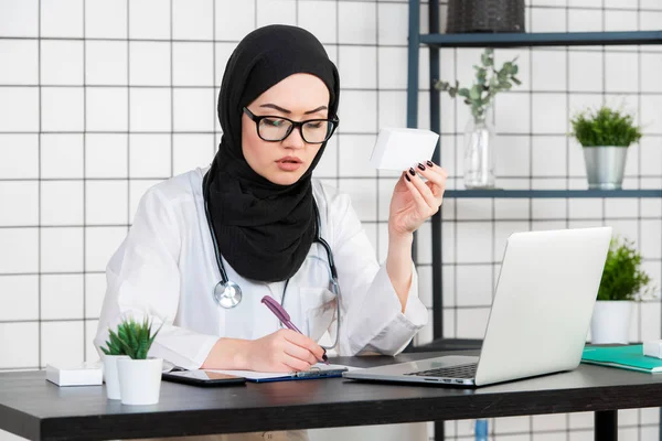 흰색 배경에 문서작업 안경과 청진기를 가진 무슬림 의사 — 스톡 사진