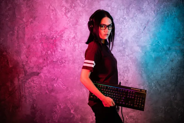 Забавная девушка-ботаник позирует с игровой клавиатурой, играет в компьютерные игры — стоковое фото