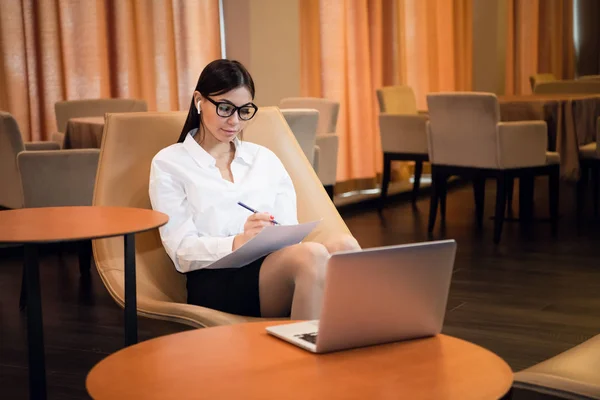 Bela jovem mulher de negócios trabalhando no computador em um lobby do hotel — Fotografia de Stock