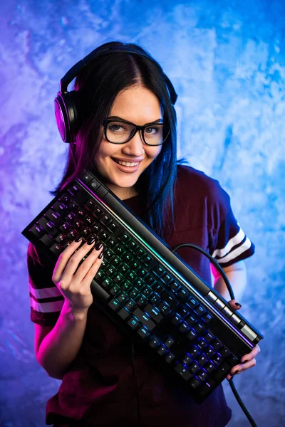 Όμορφη επαγγελματίας gamer κορίτσι με πληκτρολόγιο. Χαριτωμένο σπασικλάκι που φοράει γυαλιά και χαμογελάει. Cyber e-Sport Πρωτάθλημα Διαδικτύου. — Φωτογραφία Αρχείου