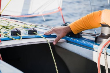 Tekne halat ile Mans el. Yatçılar, motorlu teknesini iskelenin içinde demirler. El ve tekne yay yakın.