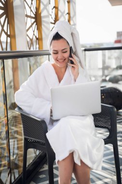 Güzel sabah konsepti. Güzel kadın kalkın ve yaz terasında dizüstü bilgisayarıyla çalışarak kahve için.