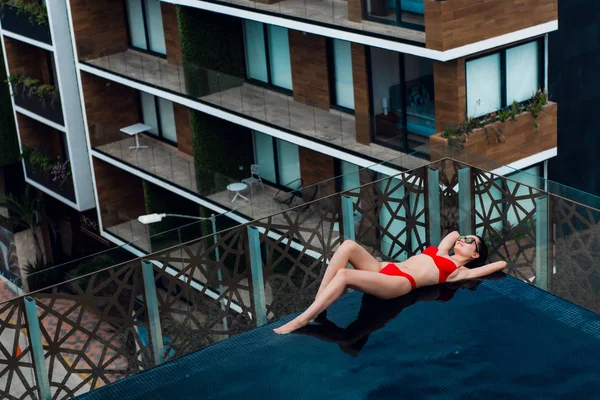 Γυναίκα που βρίσκεται σε μια ξαπλώστρα δίπλα στην πισίνα στο hotel. — Φωτογραφία Αρχείου
