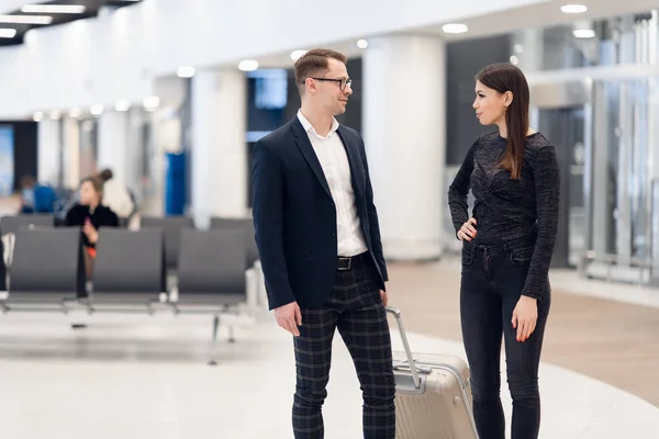 Elegant affärs par stående med resväska och flygbiljetter på vänte hallen på flygplatsen. Affärs resekoncept. — Stockfoto