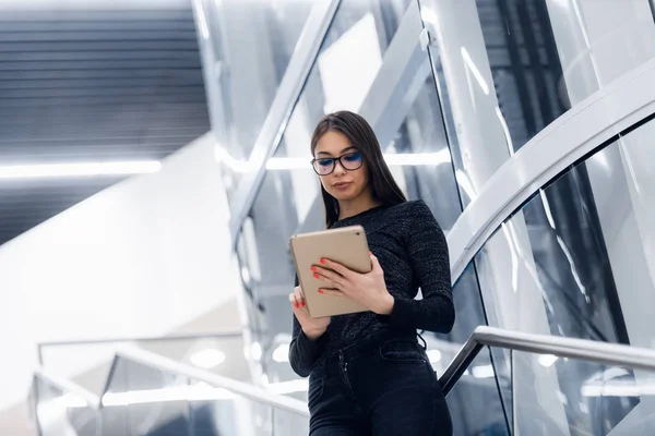 Tecnología, negocios y concepto corporativo - mujer feliz o estudiante con tablet PC de pie en las escaleras en el edificio moderno . —  Fotos de Stock
