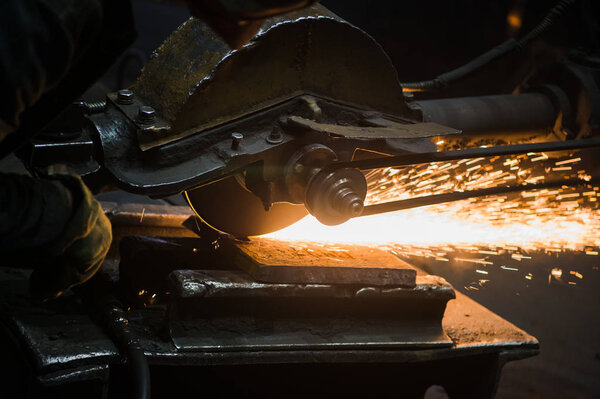 Sparks from circular saw at steel factory. Metal sawing close up.