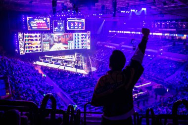 MOSCOW, RUSSIA - 14th SEPTEMBER 2019: esports Counter-Strike: Global Offensive event. Fan on a tribune at tournaments arena with hands raised. Cheering for his favorite team. clipart