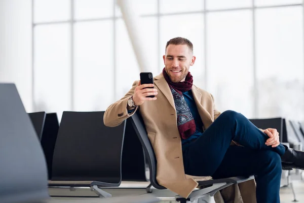 Retrato de un hombre de viaje fresco relajándose en el aeropuerto con teléfono celular —  Fotos de Stock