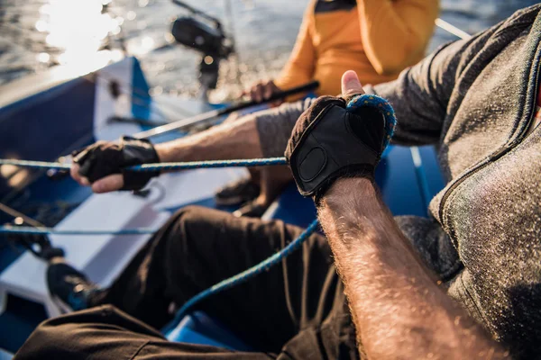 Mans kézzel csónak kötelet. Yachtsman Moors a motoros csónak móló. Közelről és hajjal a hajó. — Stock Fotó