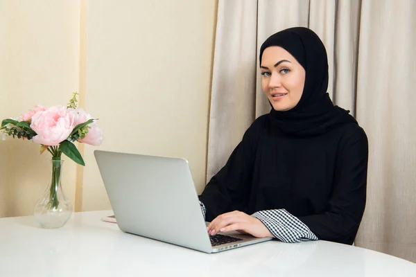 Elegante mujer musulmana atractiva usando portátil móvil que busca información de compras en línea en la sala de estar en casa — Foto de Stock