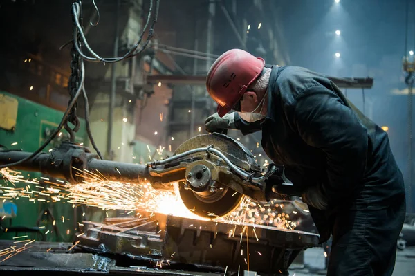NIZHNY NOVGOROD, RUSSIA - 7 ottobre 2017: Macinazione in una acciaieria. Lavoratore con una grande sega taglio metallo . — Foto Stock