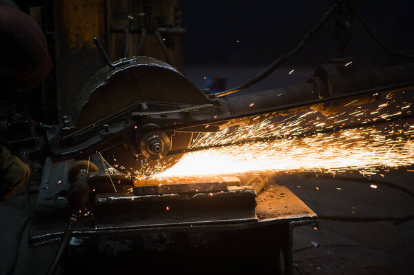 Worker grinding metal, metal grinding machine with sparks, metal sawing.