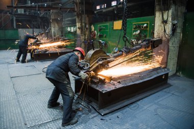 Nizhny Novgorod, Rusya - 7 Ekim 2017: Çalışma aracı ile endüstriyel işçiler. Çelik fabrikasında büyük testere elinde.