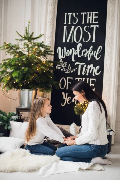 Noël et Nouvel An thème sœurs à la maison assis câlins sous le sapin de Noël rire heureux — Photo