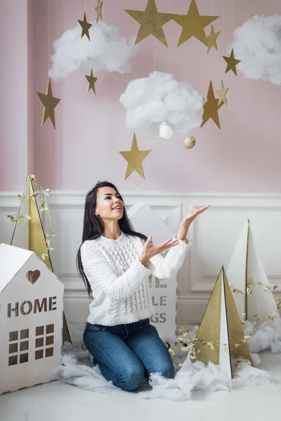 Gyönyörű fiatal nő fehér szobában karácsonyi díszek — Stock Fotó