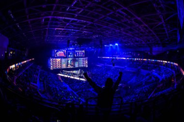 MOSCOW, RUSSIA - 14th SEPTEMBER 2019: esports Counter-Strike: Global Offensive event. Happy dedicated games fan cheering for his favorite team on a tribunes in front of a big screen with hands raised. clipart
