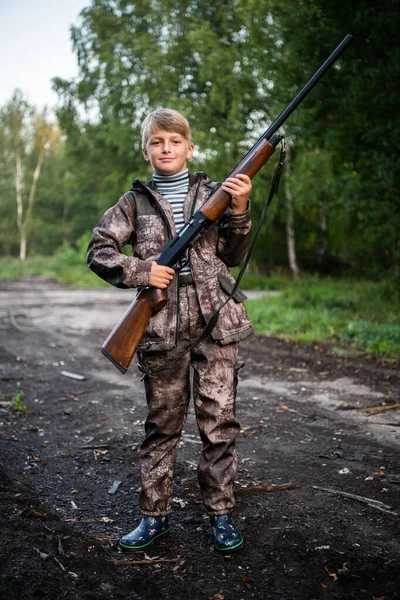 父亲给了一个儿子一支猎枪来装. 快乐的男孩准备和他的父亲一起打猎. — 图库照片