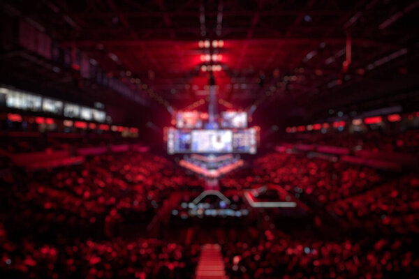 Blurred background of an esports event - Main stage venue, big screen and lights before the start of the tournament.