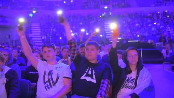 Moskwa, Rosja - 14 września 2019: esports Counter-Strike: Global Offensive event. Kibice na trybunach dopingują i wspierają swoje ulubione drużyny światłami telefonów. — Wideo stockowe