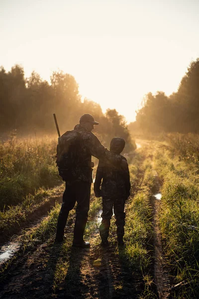 Apa az első szarvasvadászatra mutat és vezeti a fiát. — Stock Fotó