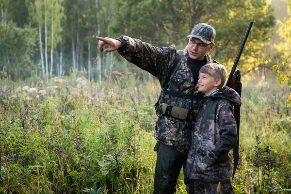 父亲用枪向儿子在性质上狩猎时显示的东西. — 图库照片