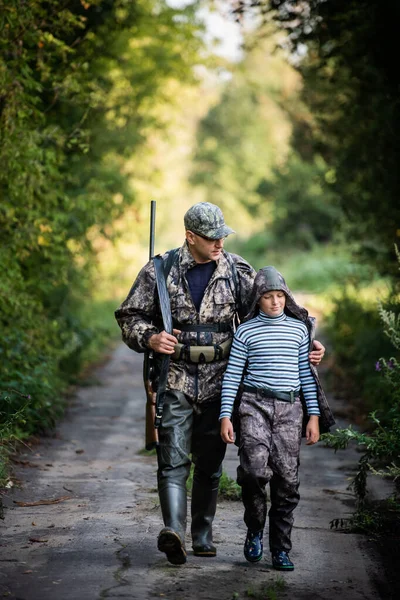 Apa az első szarvasvadászatra mutat és vezeti a fiát. — Stock Fotó