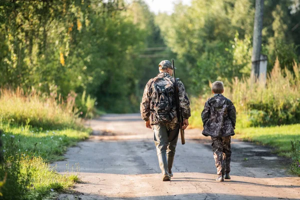 Far pekar och vägleder son på första rådjursjakt — Stockfoto