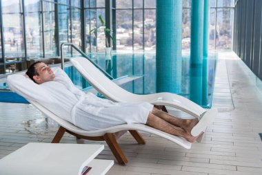 Adam kaplıcadan sonra dinleniyor. Masajdan sonraki adam. Bir adam banyodan sonra masajda dinleniyor. Kapalı havuzda uzanan bir adam var. Adam işten sonra uyuyor..