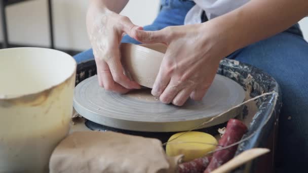 Den kvinnliga krukmakaren gjorde klart en lervas ta bort den från keramikhjulet. Skapar vas av vit lera. Göra keramiska produkter av vit lera. Närbild. — Stockvideo