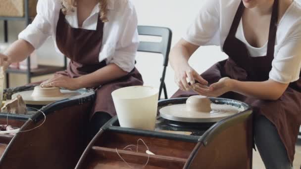 两名女陶瓷艺术家在围裙使用粘土材料工作在陶工工作室。晚上免费远程学习。成人业余爱好探险。寒冬教育休闲。现代讲习班的培训. — 图库视频影像