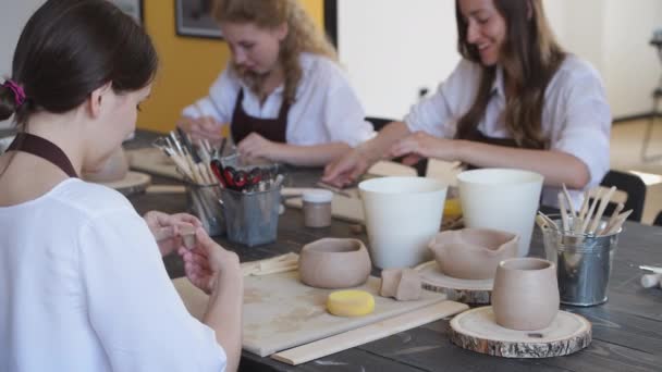 Hermosas chicas artistas jóvenes creando cerámica hecha a mano en el estudio de arte moderno. Educación niños y padres. — Vídeos de Stock