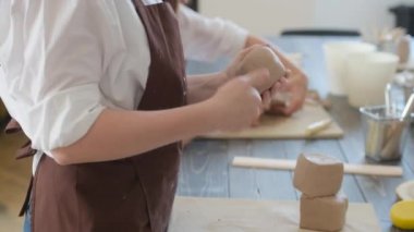 Kız ellerindeki çamuru eziyor. Çömlekçiler yakın plan çalışırlar. Kadın eli, balçığı kırıştırıyor. Hiçbir yüz kadını ellerindeki çamuru ezemez.