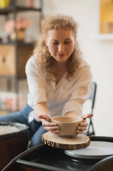 The female potter finished making a clay vase remove it from the potters wheel. Creating vase of white clay. Making ceramic products from white clay, closeup — Stock Photo, Image