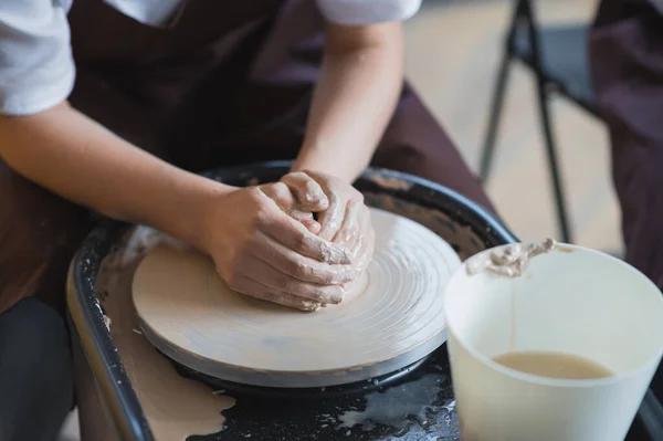 女陶工在陶瓷轮上做一个锅子. — 图库照片