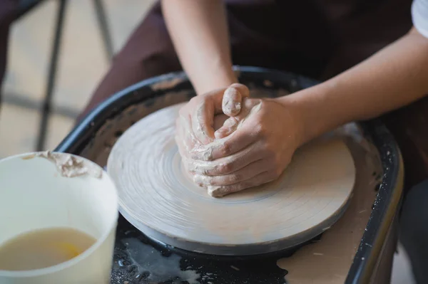 陶瓷的制造。女人在陶瓷轮上准备粘土.手的近视. — 图库照片